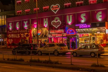 Sex House mit Neonlichtern, Autos parken in der Nacht.