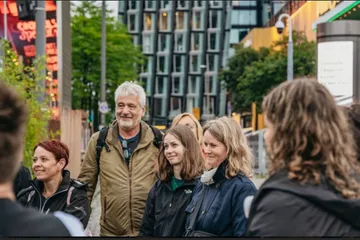 Gruppe von Menschen lächelt und unterhält sich in der Stadt.