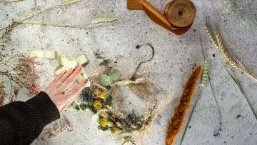 Dried flowers and ribbons are arranged on a table.