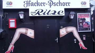 Schwarze Tür mit beidseitigen, künstlerischen Frauenbeinen.