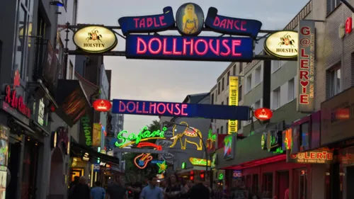 Colourful neon lights glow over a busy street.
