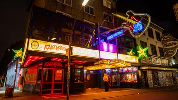 Neon lighting illuminates a nightclub in an urban setting.