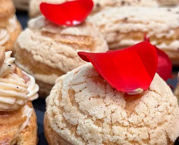 Delicious pastries decorated with red rose petals