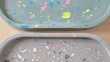 Zwei Betonablagen mit buntem, speckigem Muster liegen nebeneinander.