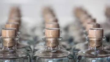Glasflaschen mit Korken stehen in einer Reihe angeordnet.