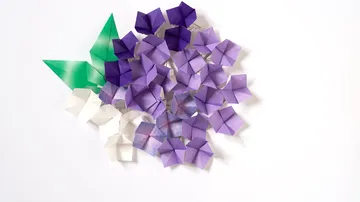 Colourful origami flowers lie on a white background.