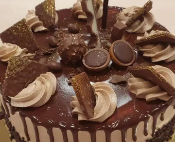 Chocolate cake with decorative candy and cream.
