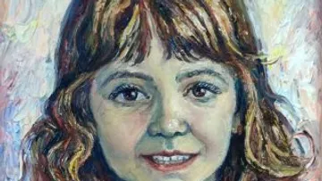 Portrait of a girl with brown curls, smiling.