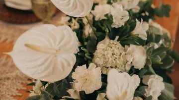 Weiße Blumen arrangiert in einer eleganten Tischdekoration.