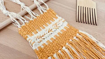 Gewebtes Makramee-Stück auf Holzoberfläche.