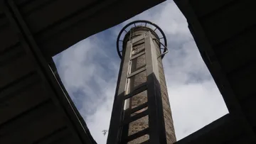 Hoher Schornstein ragt in den Himmel über einer Öffnung.