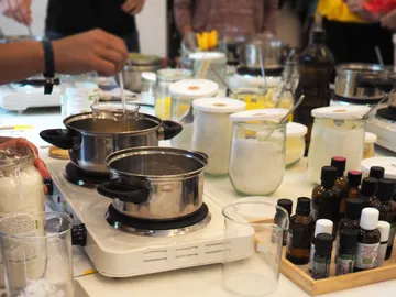 Cook pots on stove, surrounded by lots of ingredients and containers.
