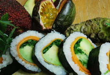 Sushi rollt mit frischen Zutaten auf einem Holzbrett.