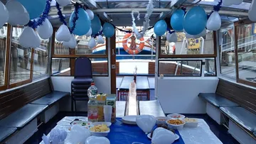 Bootsinnenraum mit blauen Luftballons und Snacks auf Tisch.