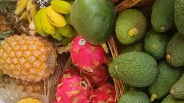 Colourful fruits lie in a basket at a market.