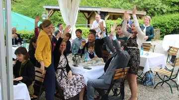 Eine Gruppe feiert aktiv beim Essen im Freien.