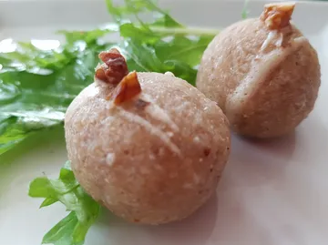 Kugelförmige Snacks liegen auf grünem Salatblatt.