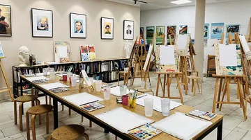 An art studio with empty easels and painting materials.