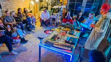 Eine Gruppe hört einem Vortrag und experimentiert mit Musik.
