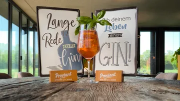 Ein Cocktail steht auf einem Tisch mit dekorativen Schildern.