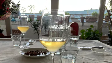 Ein Glas Wein steht auf einem Tisch in einem Restaurant.