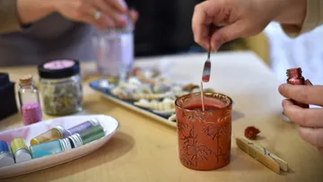 Person crafting candle at a table.
