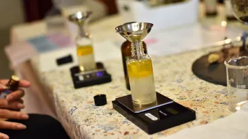 Perfume-making setup with funnel and scales.