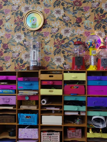 Wooden rack with colorful drawers and gumball machine.