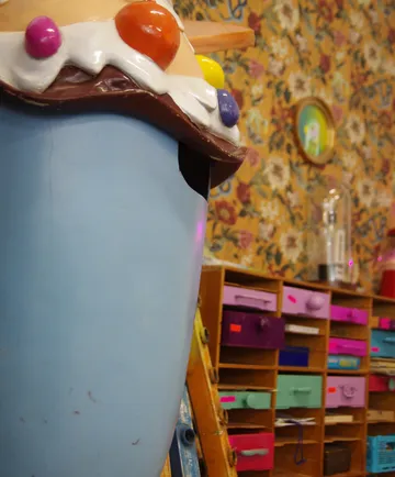 There is a large, colorfully decorated ice cream sundae in the room.