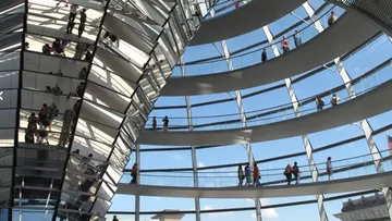 Moderne Kuppel mit Besuchern, unter blauem Himmel.