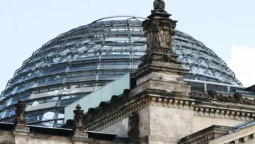 Kuppel aus Glas über historische Gebäudestruktur in Berlin.