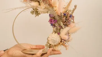 Bunte Trockenblumen in einem halbkreisförmigen Arrangement halten.