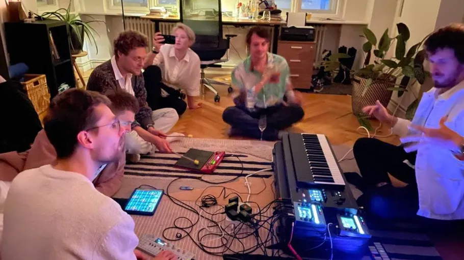 Musiker sitzen um elektronische Instrumente und kreativ produzieren Musik.