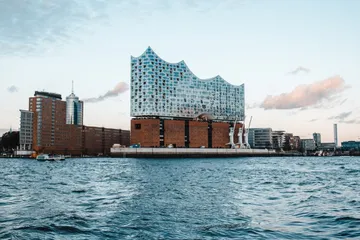 Moderne Architektur, reflektiert Wasser, umgebend von Stadtlandschaft.