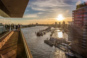 View of sunset over a harbor with buildings.