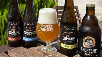 Biere stehen auf einem Tisch in einer sonnigen Umgebung.
