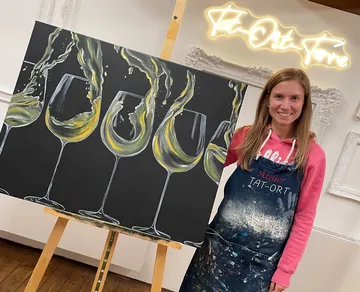 An artist presents a painting with wine glasses.