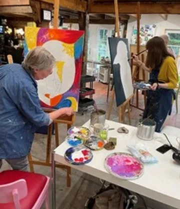 Zwei Künstler malen in einem hellen Atelier.