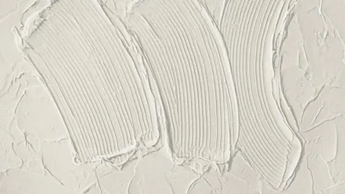 Three white brush strokes on a smooth, bright surface