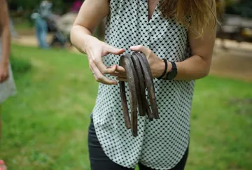 Frau hält mehrere Hufeisen in einem Park.