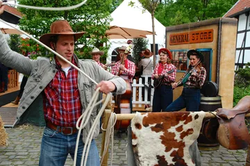 Ein Cowboy wirbelt mit einem Lasso auf einem Fest.