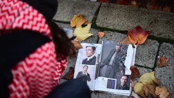 Aufgeschlagenes Magazin liegt auf dem Boden zwischen Herbstlaub.