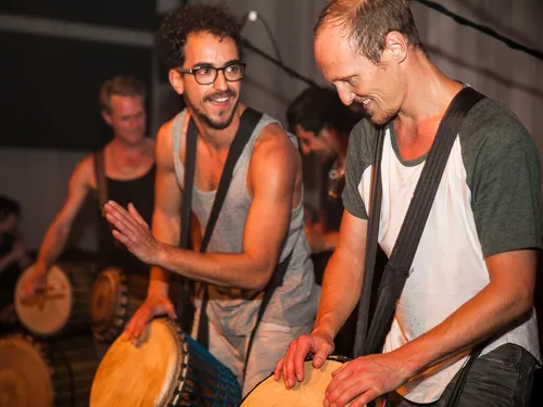 Zwei Männer spielen auf Trommeln in einer Bühne.