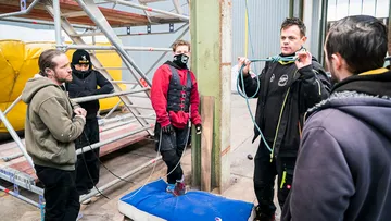 Four people are standing in a warehouse and studying.