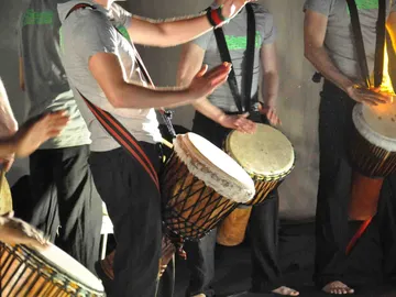 Drummers play enthusiastically on traditional drums in groups.