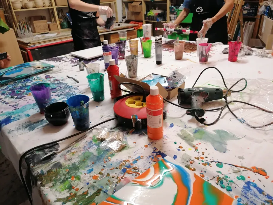 Tisch mit Farbtöpfen, Bemalen in kreativem Atelier.