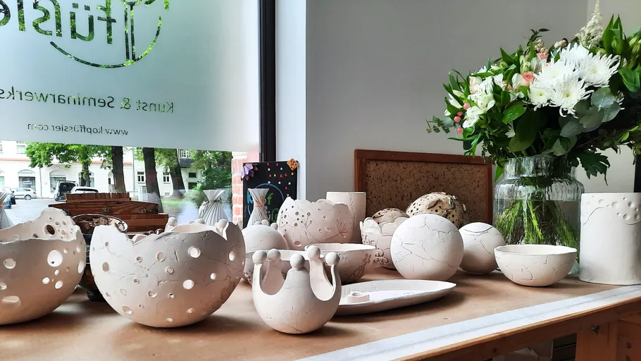 Handcrafted ceramic bowls on a table near flowers.