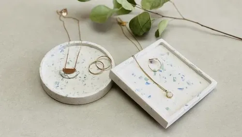 Jewelry is placed on ceramic shelves in a natural environment.