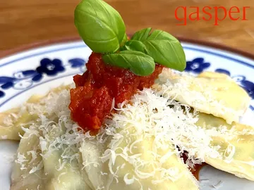 Pasta with tomato sauce and fresh basil on plate.