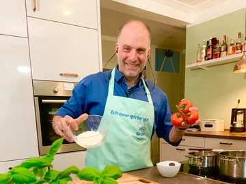 A man keeps tomatoes and a bowl of flour in the kitchen.